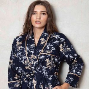 Aloha Gold cotton dressing gown UK is stylish and beautiful. The colour is a rich deep blue with gold and white printed leaves and exotic flowers, the gown is made from luxury soft 100% cotton. It has a stunning shawl design collar which has a pretty gold satin trim, and this also extends around the cuffs of the long sleeves. There are two pockets, an internal tie and external tie, to aid that comfortable wear. A cotton dressing gown UK right for lounging around in. 