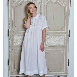 Cotton Short Sleeved Nightdress - Agatha is a sweet little white nightdress with lots of style and a comfortable cut with a full skirt for ease of movement. The Sleeves are elasticated and have a broderie anglaise trim, the embroidered collar has a prettily fluted edge, and the neck opens with four buttons. This Cotton short sleeved nightdress has a decorated hemline has ladder stitch detailing and is edged with more broderie anglaise lace trim.